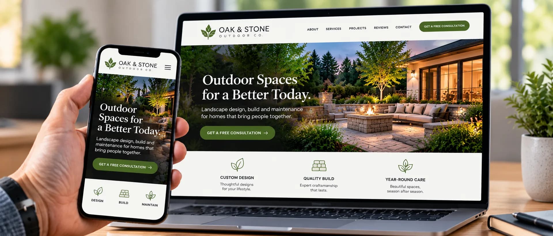 A laptop and a phone on a desk, both showing the same landscaping company's website: a photo of a lit patio with a fire pit, the headline “Outdoor Spaces for a Better Today” and a green “Get a free consultation” button.